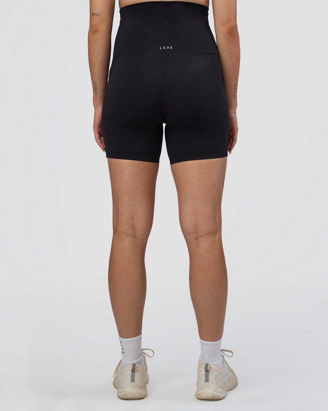 Woman wearing Elixir Ultra High-Rise Maternity 6&quot; Short Pockets - Black | Model:Kitahna | Size:S