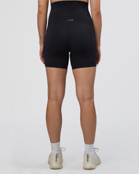 Woman wearing Elixir Ultra High-Rise Maternity 6" Short Pockets - Black | Model:Kitahna | Size:S