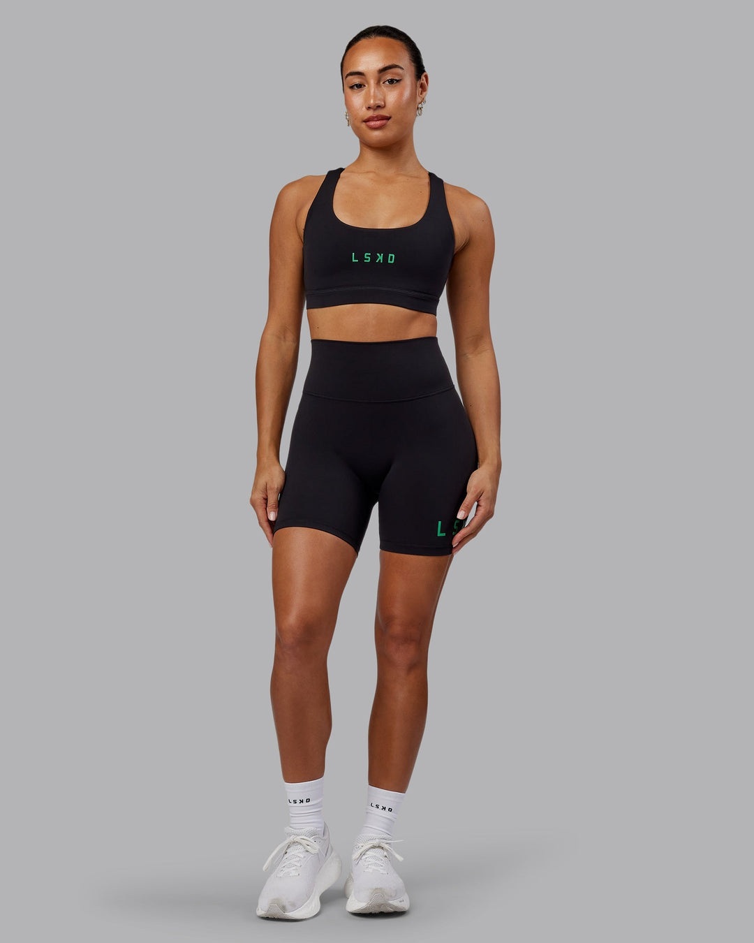 Woman wearing Evolved Mid-Length Shorts - Black-Impact Green