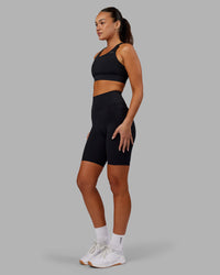Woman wearing Fusion Ultra High-Rise 9" Short Pockets - Black | Model:Kirstyn | Size:S