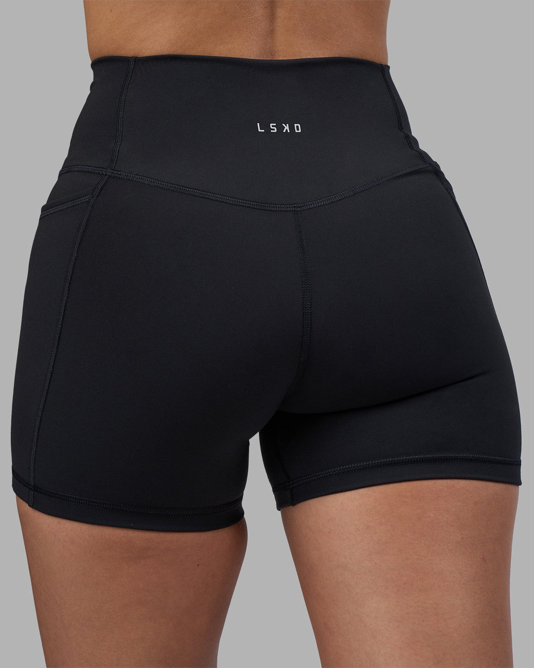 Woman wearing Fusion High-Rise 4&quot; Short Pockets - Black | Model:Rhiley | Size:S