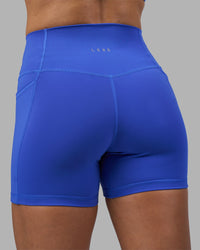 Woman wearing Fusion High-Rise 4" Short Pockets - Power Cobalt | Model:Hannah | Size:S