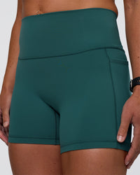 Woman wearing Fusion High-Rise 4" Short Pockets - Transformative Teal | Model:Sav | Size:S