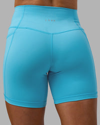 Woman wearing Fusion High-Rise 6" Short Pockets - Blue Atoll | Model:Georgia | Size:S