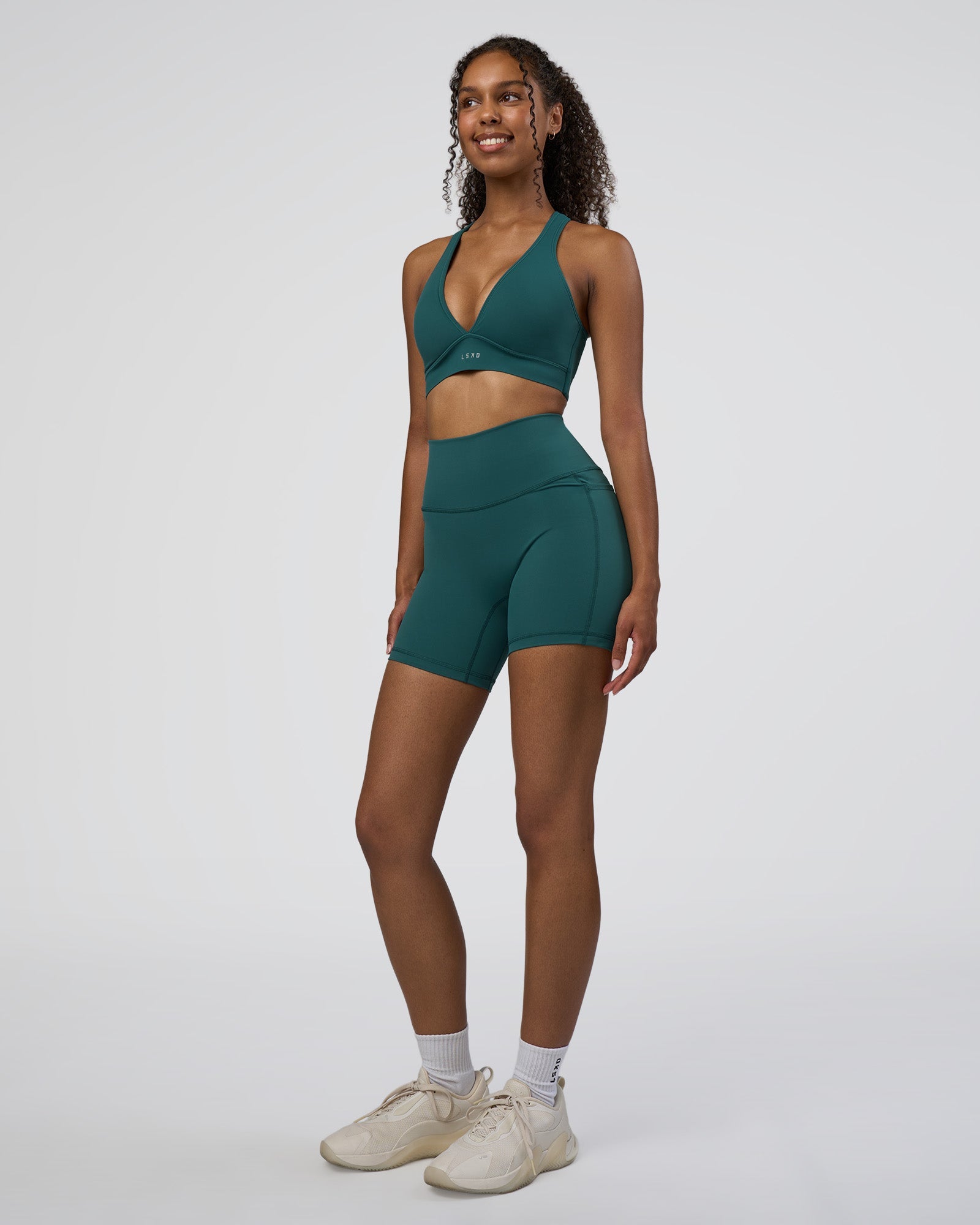 Woman wearing Fusion High-Rise 6" Short Pockets - Transformative Teal | Model:Jordan | Size:S