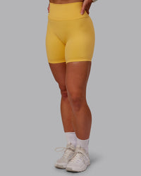 Woman wearing Fusion Ultra High-Rise 6" Short - Banana Cream | Set:true | Angle:side | Model:Amber | Size:S