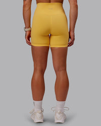 Woman wearing Fusion Ultra High-Rise 6" Short - Banana Cream | Set:true | Angle:back | Model:Amber | Size:S