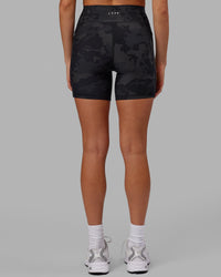 Woman wearing Fusion Ultra High-Rise 6" Short Pockets - Black Camo | Model:Katie | Size:S