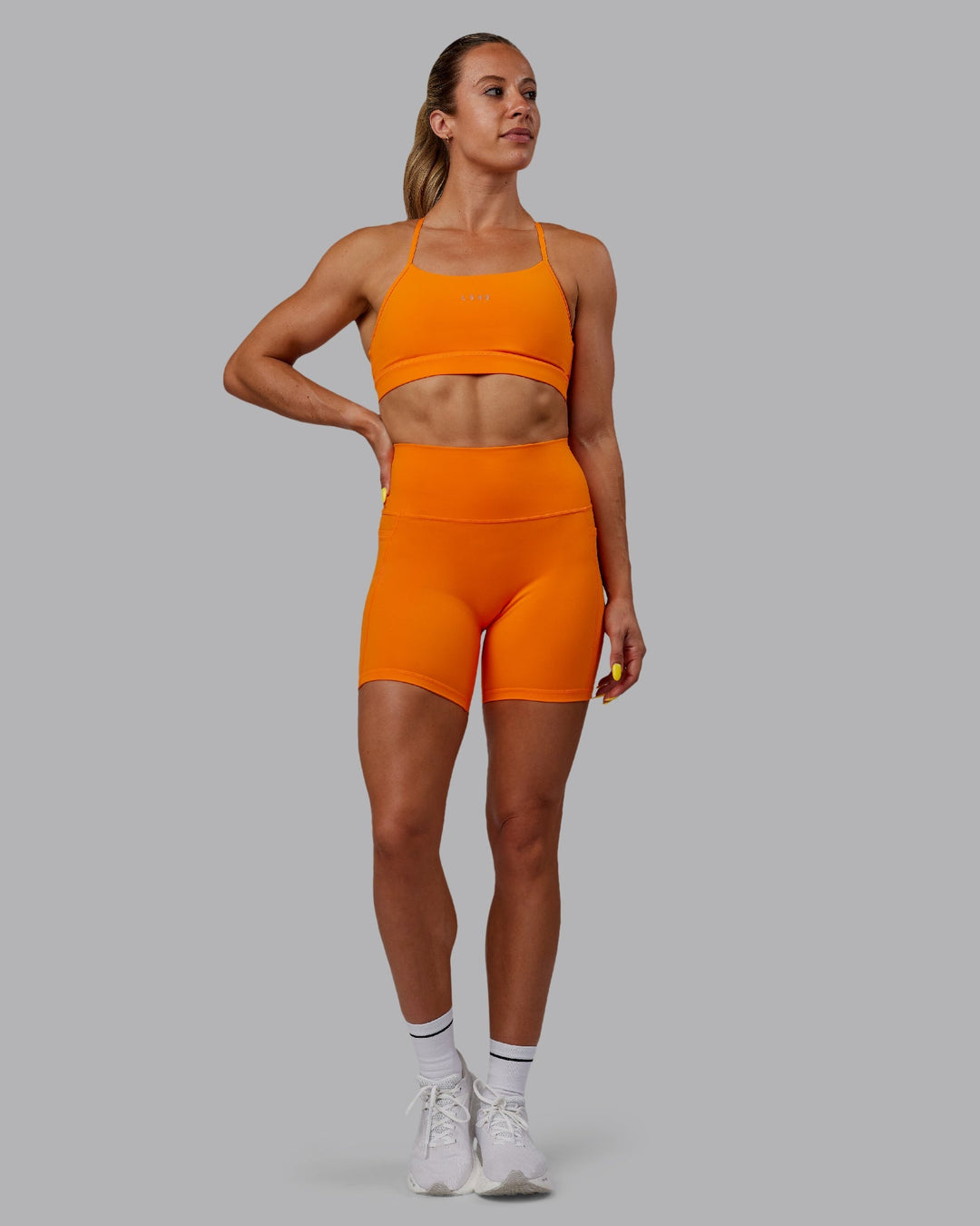 Woman wearing Fusion Mid-Length Shorts - Vibrant Orange