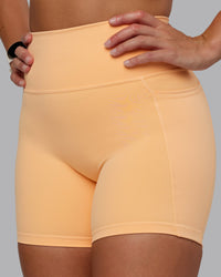 Woman wearing Fusion Ultra High-Rise 6" Short Pockets - Peach Fuzz | Model:Lyss | Size:S