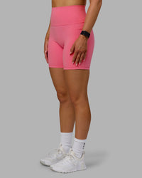 Woman wearing Fusion Ultra High-Rise 6" Short Pockets - Pink Lemonade | Set:true | Angle:side | Model:Halle | Size:S