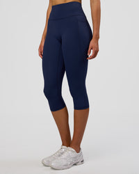 Woman wearing Fusion Ultra High-Rise 3/4 Legging Pockets - Future Navy | Model:Evie | Size:S