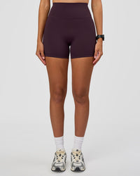 Woman wearing Fusion Ultra High-Rise 4" Short - Midnight Plum | Set:true | Angle:front | Model:Rhiley | Size:S
