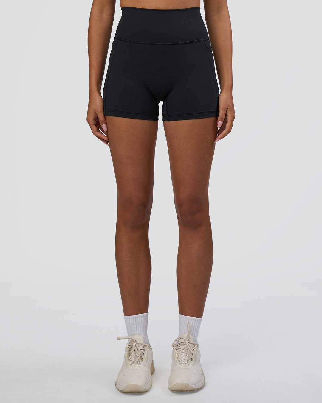 Woman wearing Fusion Ultra High-Rise 4&quot; Short Pockets - Black | Model:Ruby | Size:S