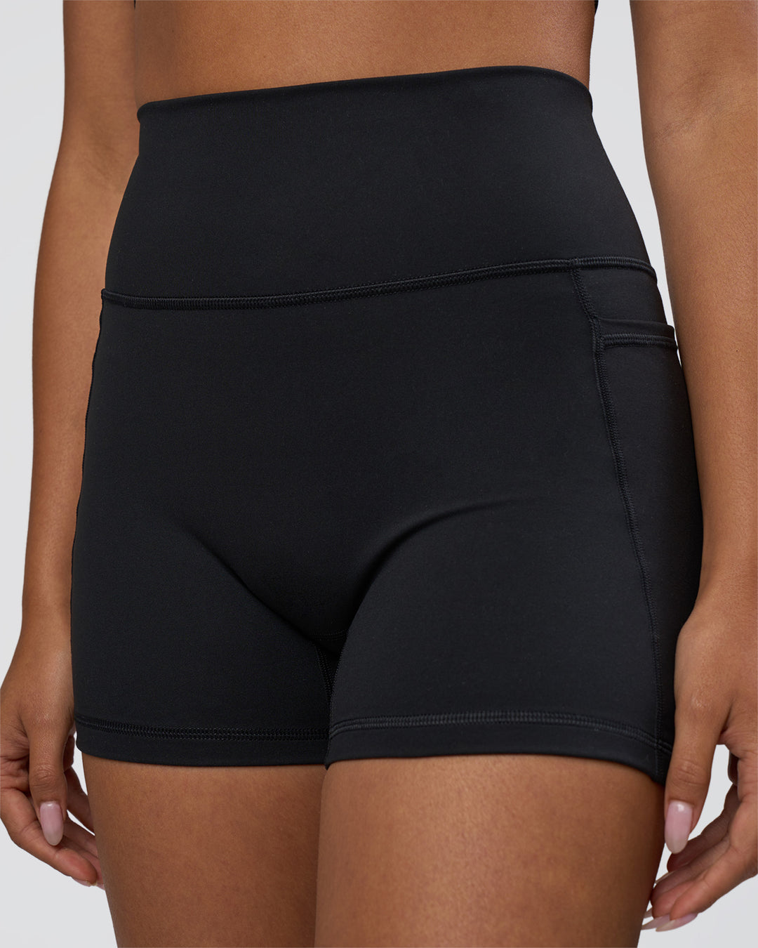 Woman wearing Fusion Ultra High-Rise 4&quot; Short Pockets - Black | Model:Ruby | Size:S