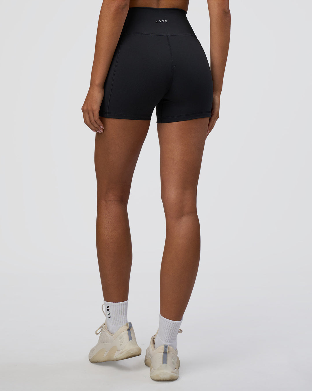 Woman wearing Fusion Ultra High-Rise 4&quot; Short Pockets - Black | Model:Ruby | Size:S