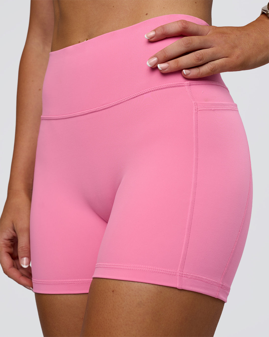 Woman wearing Fusion Ultra High-Rise 4&quot; Short Pockets - Candy Pink | Model:Emelia | Size:S