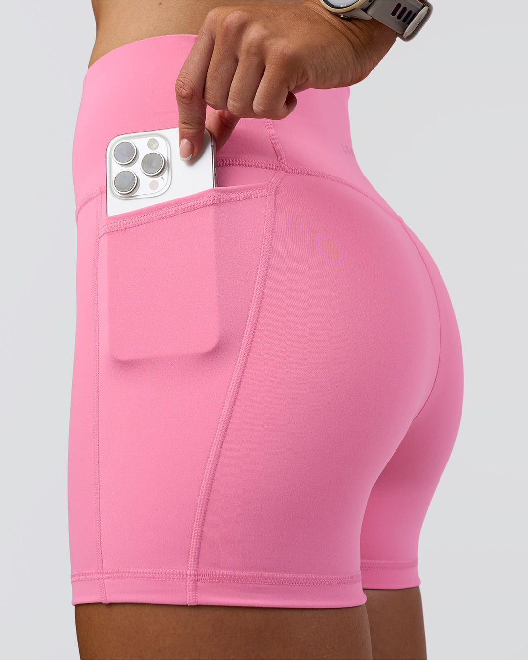 Woman wearing Fusion Ultra High-Rise 4&quot; Short Pockets - Candy Pink | Model:Emelia | Size:S