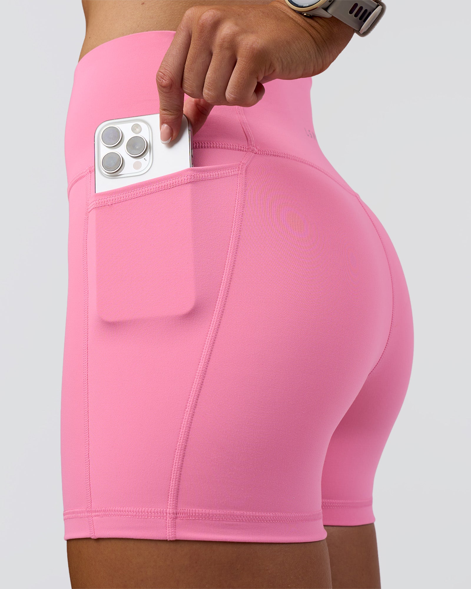 Woman wearing Fusion Ultra High-Rise 4" Short Pockets - Candy Pink | Model:Emelia | Size:S