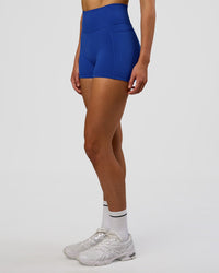 Woman wearing Fusion Ultra High-Rise 4" Short Pockets - Electric Indigo | Model:Evie | Size:S