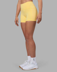 Woman wearing Fusion Ultra High-Rise 4" Short Pockets - Lemon | Set:true | Angle:side | Model:Sophie | Size:S