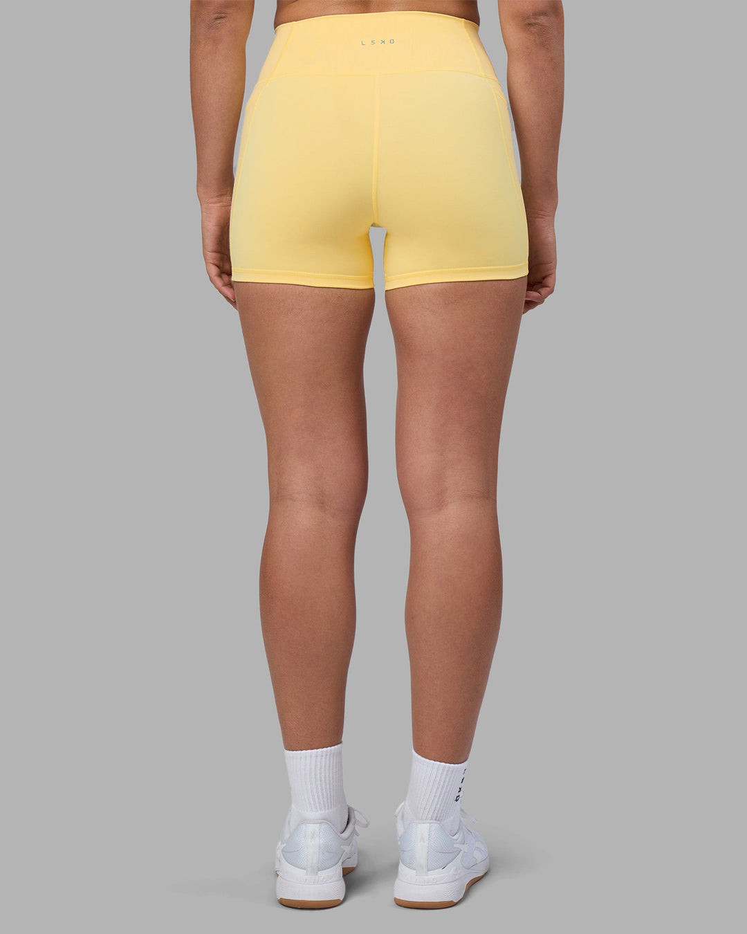 Woman wearing Fusion Ultra High-Rise 4" Short Pockets - Lemon | Set:true | Angle:back | Model:Sophie | Size:S