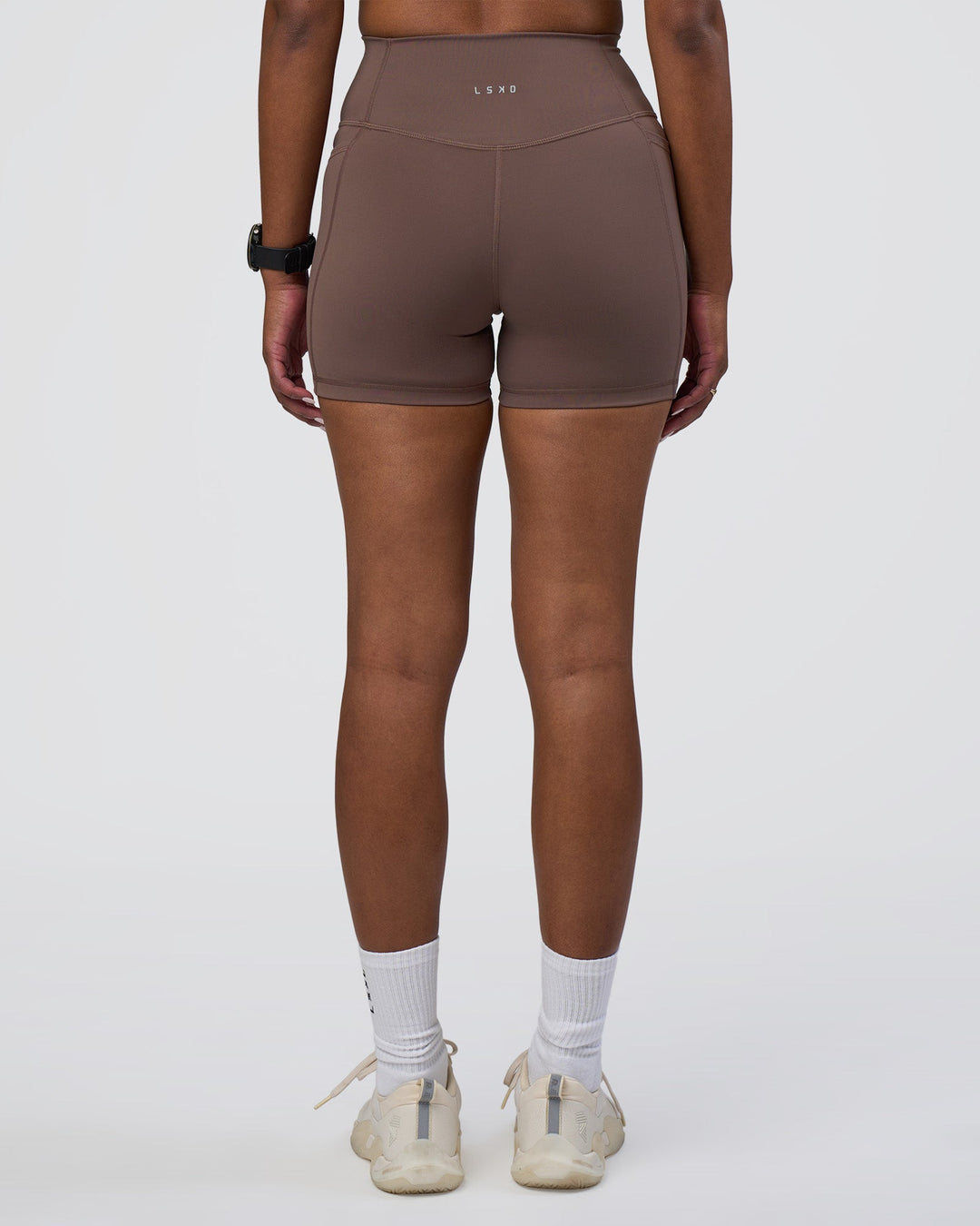Woman wearing Fusion Ultra High-Rise 4" Short Pockets - Peppercorn | Set:true | Angle:back | Model:Rica | Size:S