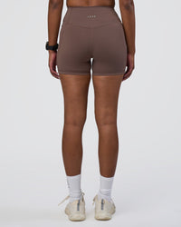 Woman wearing Fusion Ultra High-Rise 4" Short Pockets - Peppercorn | Set:true | Angle:back | Model:Rica | Size:S