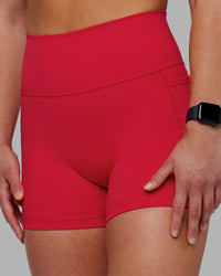 Woman wearing Fusion Ultra High-Rise 4" Short Pockets - Scarlet | Model:Keisha | Size:S