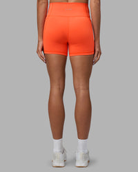Woman wearing Fusion Ultra High-Rise 4" Short Pockets - Ultra Orange | Set:true | Angle:back | Model:Katie | Size:S