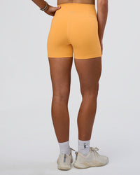 Woman wearing Fusion Ultra High-Rise 4" Short Pockets - Warm Apricot | Model:Emelia | Size:S