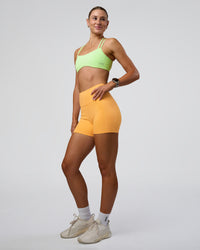 Woman wearing Fusion Ultra High-Rise 4" Short Pockets - Warm Apricot | Model:Emelia | Size:S