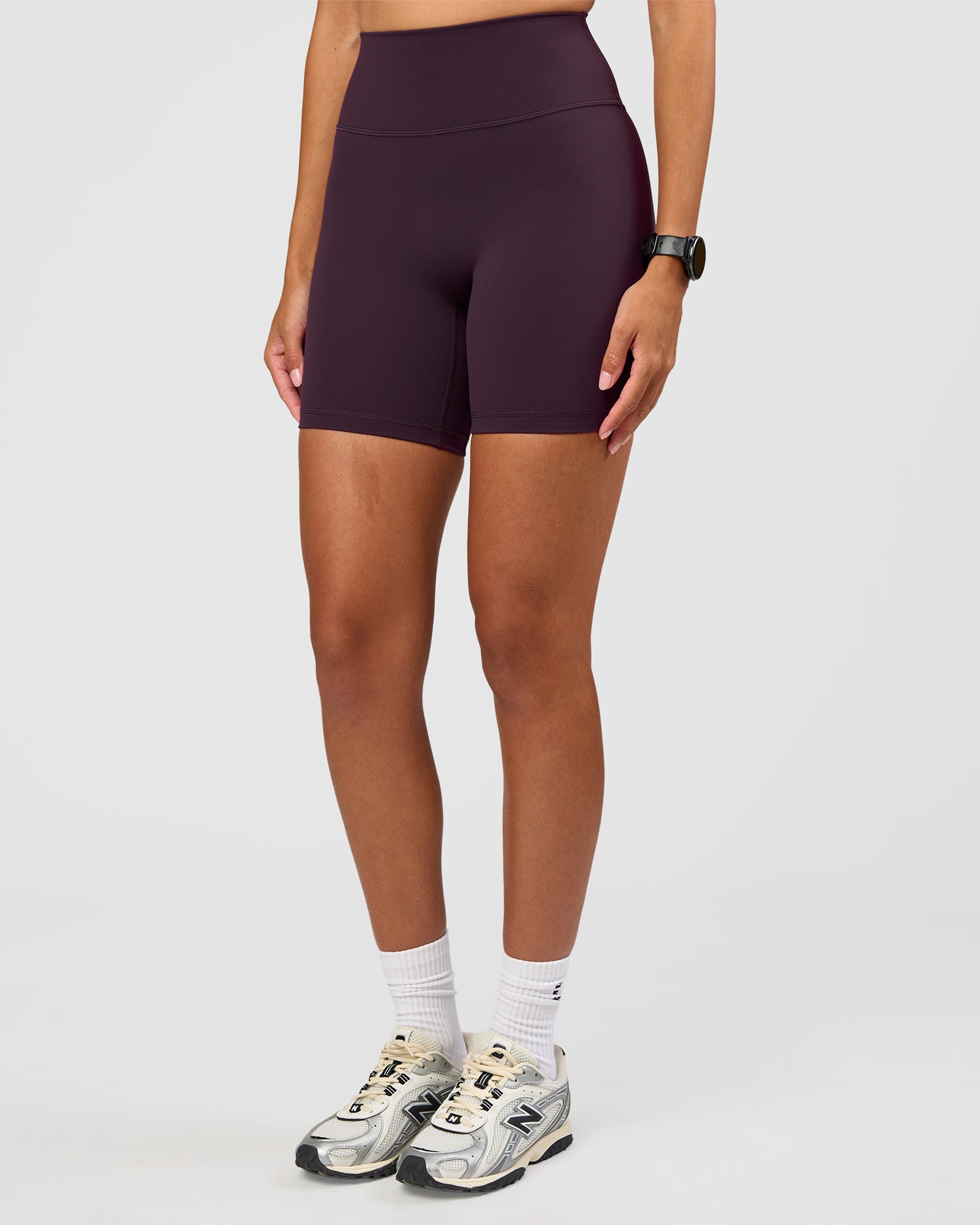 Woman wearing Fusion Ultra High-Rise 6" Short - Midnight Plum | Set:true | Angle:side | Model:Rhiley | Size:S