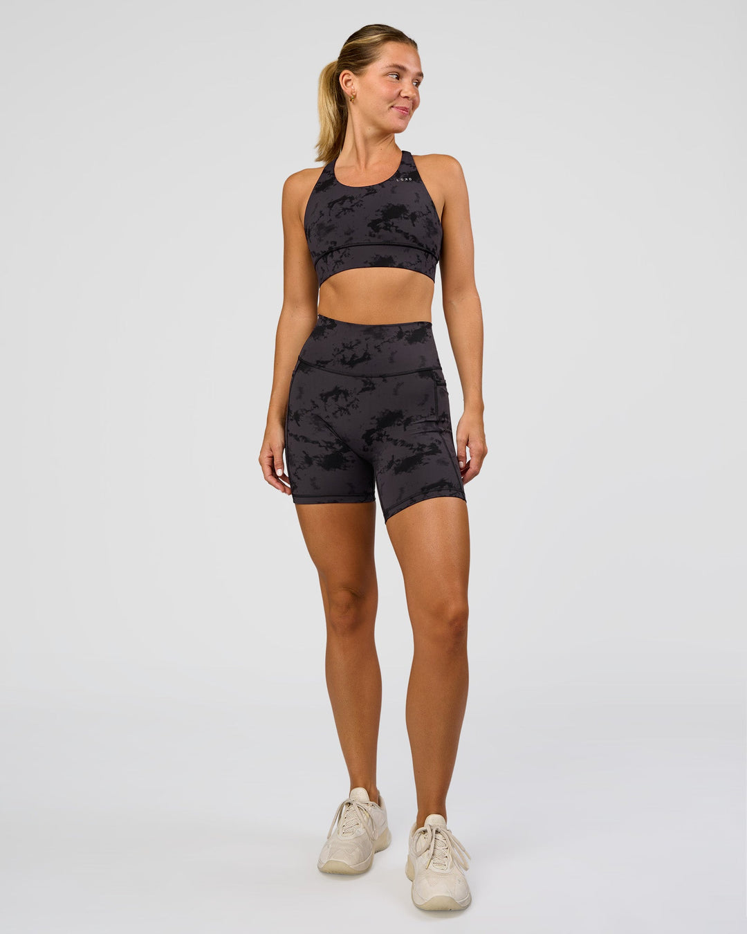 Woman wearing Fusion Ultra High-Rise 6" Short Pockets - Black Tie Dye | Model:Amity | Size:S