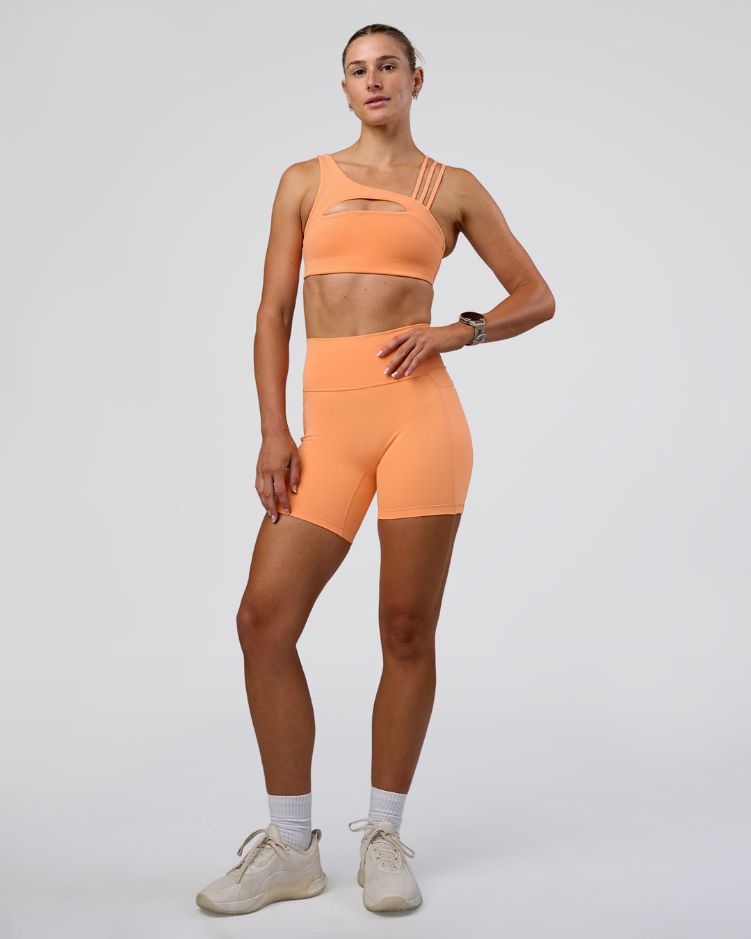 Woman wearing Fusion Ultra High-Rise 6" Short Pockets - Cantaloupe | Model:Emelia | Size:S
