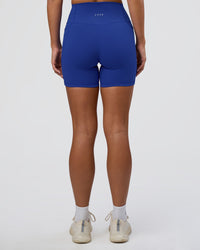 Woman wearing Fusion Ultra High-Rise 6" Short Pockets - Electric Indigo | Set:true | Angle:back | Model:Amity | Size:S