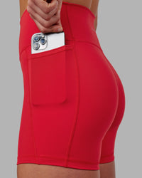 Woman wearing Fusion Ultra High-Rise 6" Short Pockets - Scarlet | Set:true | Angle:closeup | Model:Keisha | Size:S
