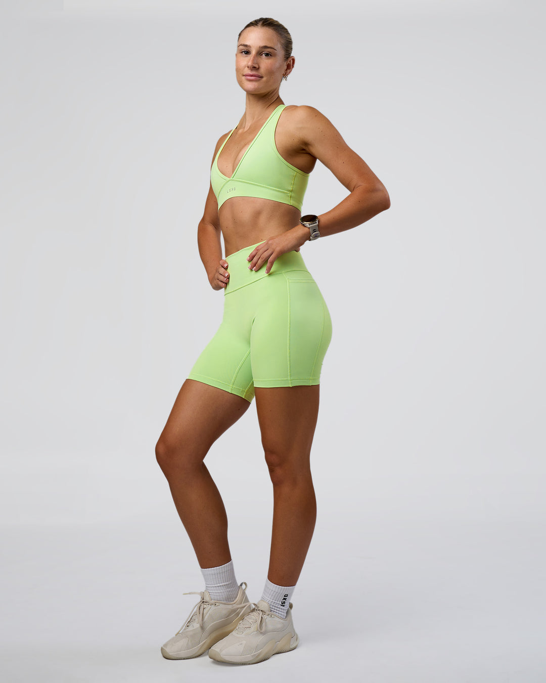 Woman wearing Fusion Ultra High-Rise 6&quot; Short Pockets - Solar Lime | Model:Emelia | Size:S