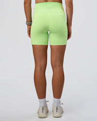 Woman wearing Fusion Ultra High-Rise 6" Short Pockets - Solar Lime | Set:true | Angle:back | Model:Emelia | Size:S