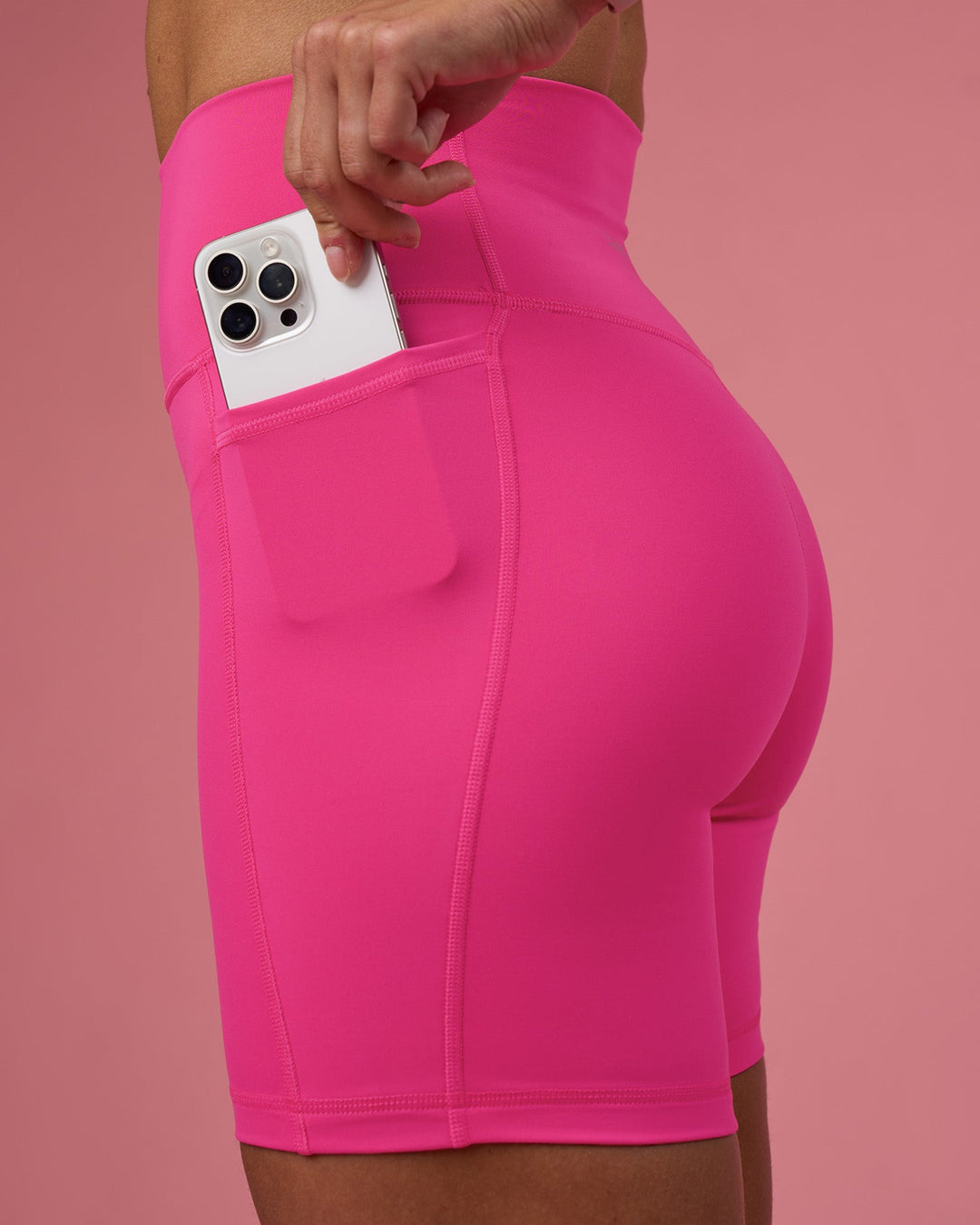 Woman wearing Fusion Ultra High-Rise 6" Short Pockets - Ultra Pink | Set:true | Angle:closeup | Model:Hannah | Size:S