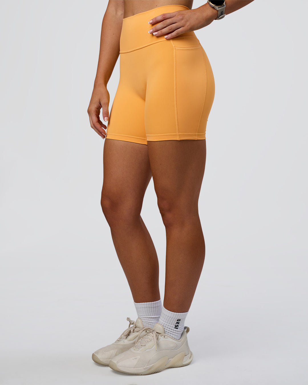 Woman wearing Fusion Ultra High-Rise 6&quot; Short Pockets - Warm Apricot | Model:Emelia | Size:S