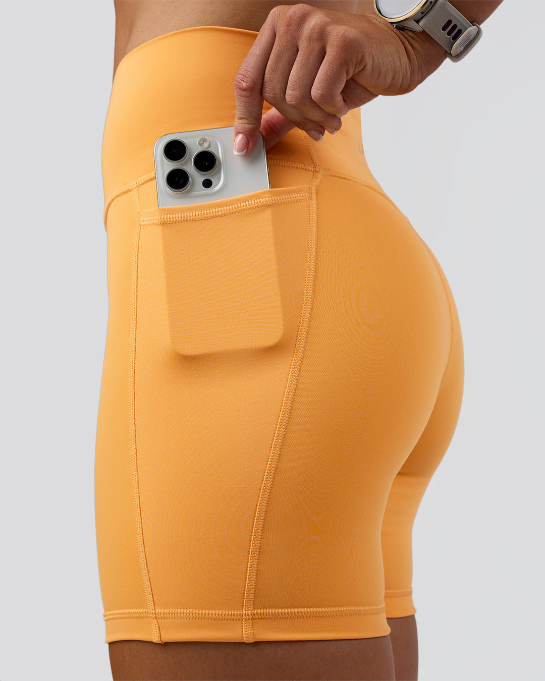Woman wearing Fusion Ultra High-Rise 6&quot; Short Pockets - Warm Apricot | Model:Emelia | Size:S