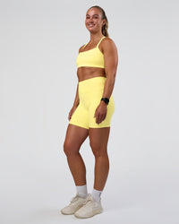 Woman wearing Fusion Ultra High-Rise 6" Short Pockets - Yellow Fizz | Model:Sav | Size:S