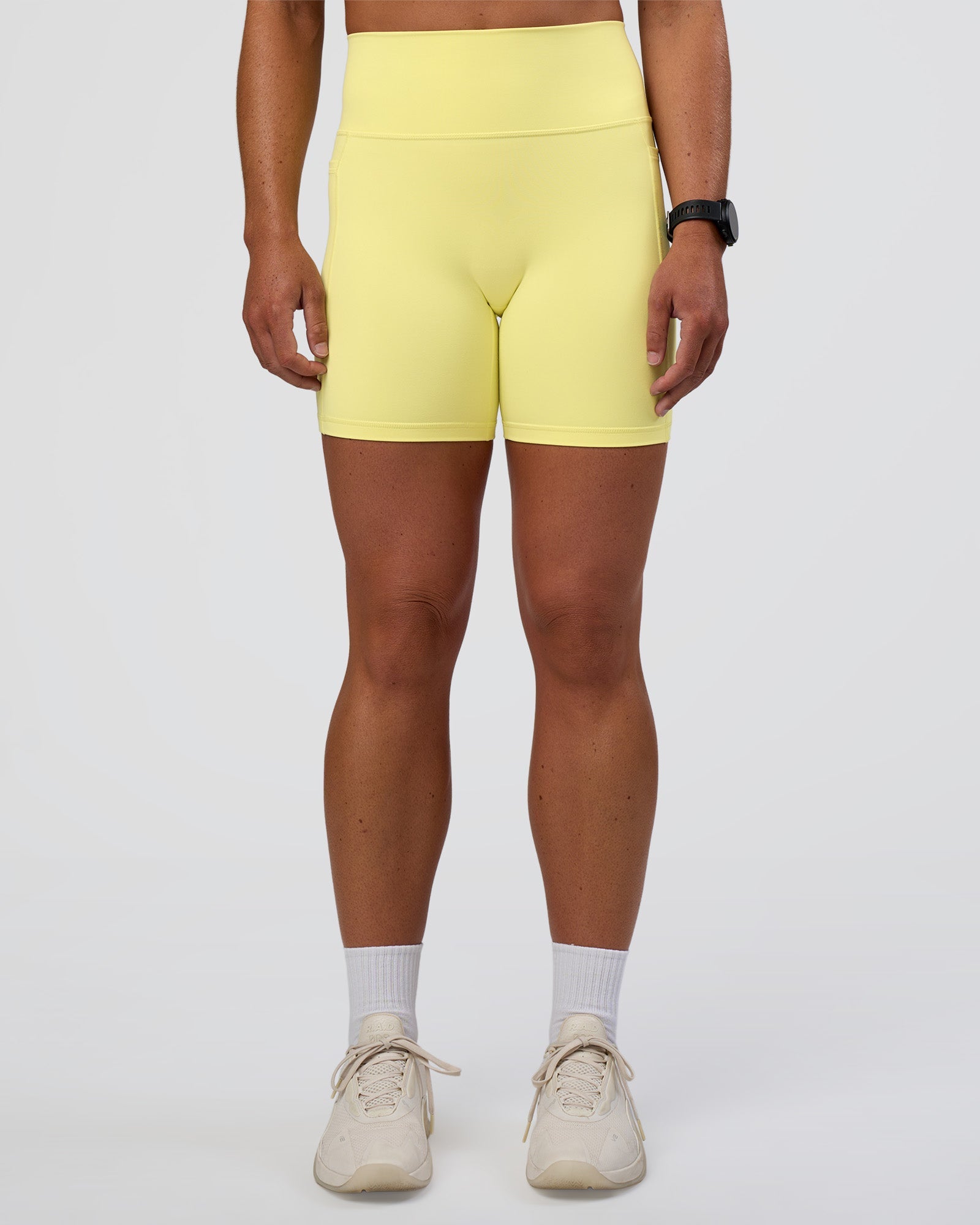 Woman wearing Fusion Ultra High-Rise 6" Short Pockets - Yellow Fizz | Set:true | Angle:front | Model:Sav | Size:S