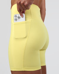 Woman wearing Fusion Ultra High-Rise 6" Short Pockets - Yellow Fizz | Set:true | Angle:closeup | Model:Sav | Size:S