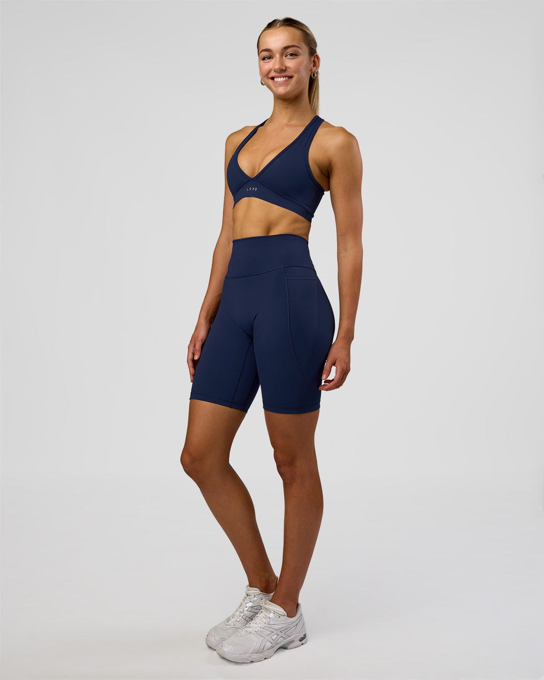 Woman wearing Fusion Ultra High-Rise 9&quot; Short Pockets - Future Navy | Model:Evie | Size:S
