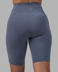 Woman wearing Fusion Ultra High-Rise 9" Short Pockets - Night Shadow | Model:Rhiley | Size:S