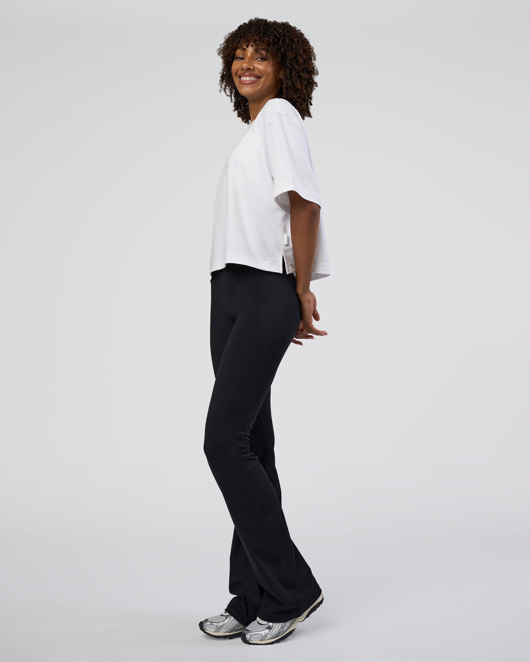 Woman wearing Fusion Ultra High-Rise Flared Tall Legging Pockets - Black | Model:Tomi | Size:S