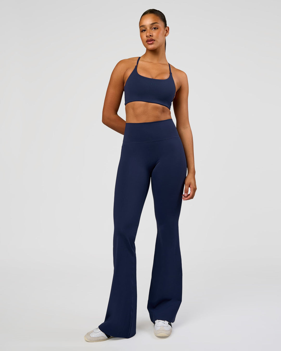 Woman wearing Fusion V-Contour High-Rise Flared Tall Legging Pockets - Future Navy | Model:Rosie | Size:S