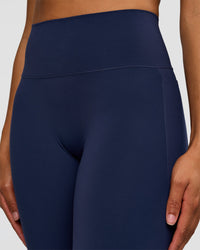 Woman wearing Fusion V-Contour High-Rise Flared Tall Legging Pockets - Future Navy | Model:Rosie | Size:S